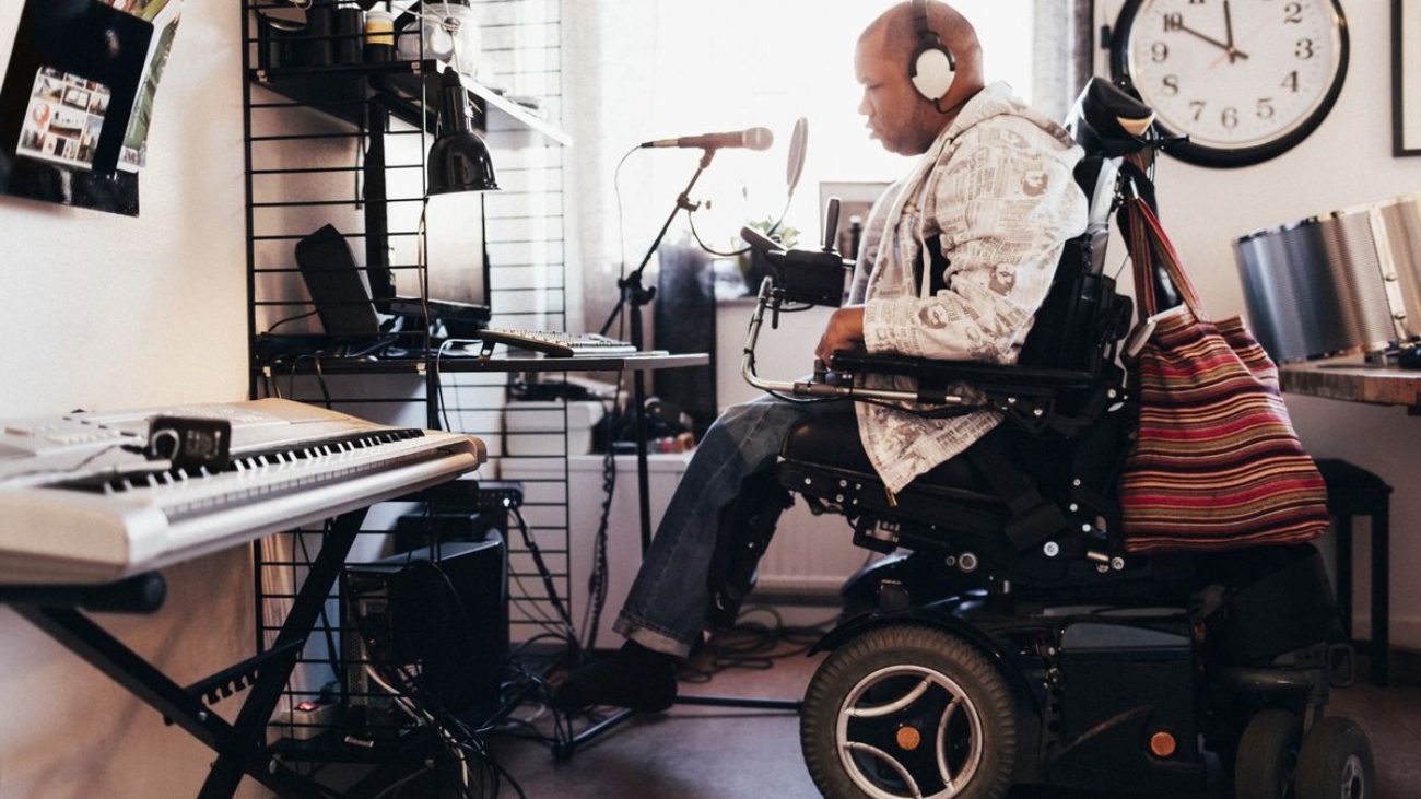 Side view of disabled musician with headphones in recording studio